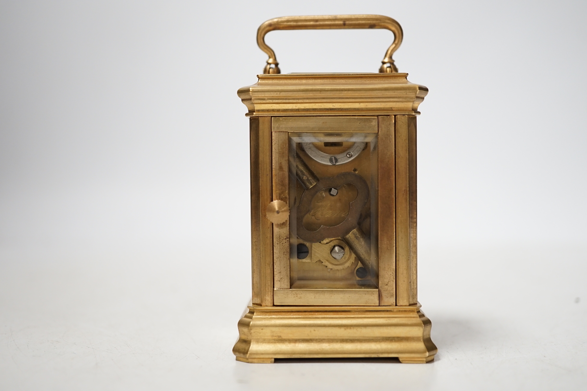 A small brass cased carriage timepiece with key, 9cm high